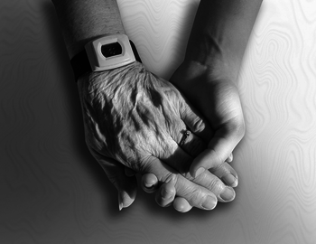 Eine älter ausschauende Hand wird von einer jünger aussehenden Hand gehalten