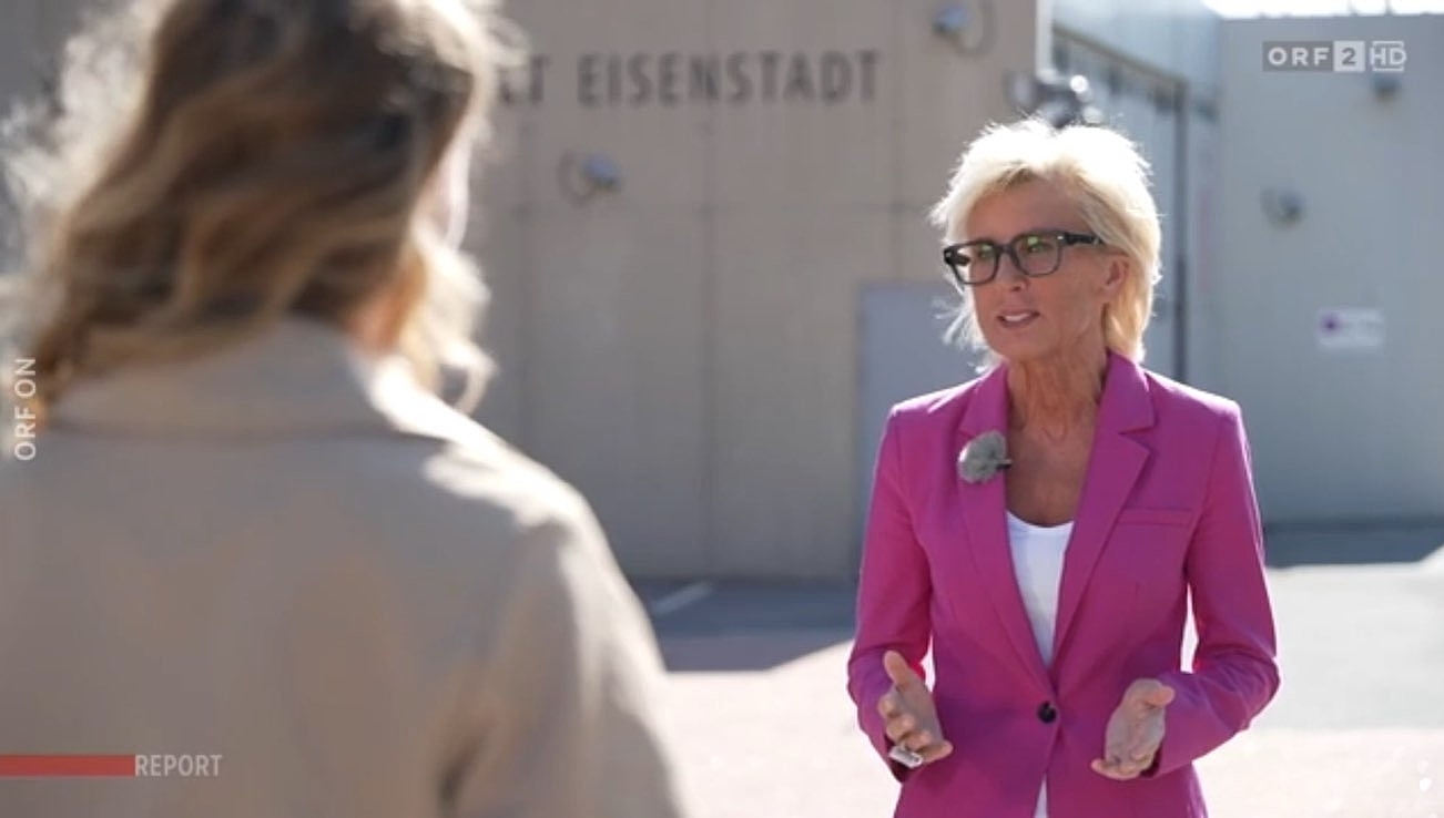 Volksanwältin Gaby Schwarz steht mit einer Journalistin vor der Justizanstalt Eisenstadt und gibt ein Interview.