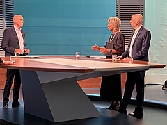 The Ombudsperson stands in the public television channel ORF studio between the presenter and the complainant