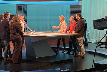 Volksanwältin steht im ORF Studio mit weiteren 6 Personen