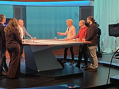 Ombudswoman stands in the ORF studio with 6 other people