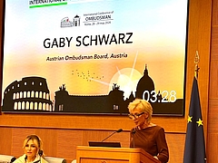 Volksanwältin Gaby Schwarz steht am Rednerpult und hält eine Rede.