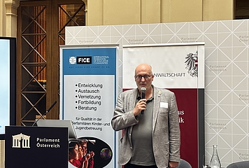FICE-Austria-Präsident Christian Posch am Redner*innenpult im Palais Epstein, Wien