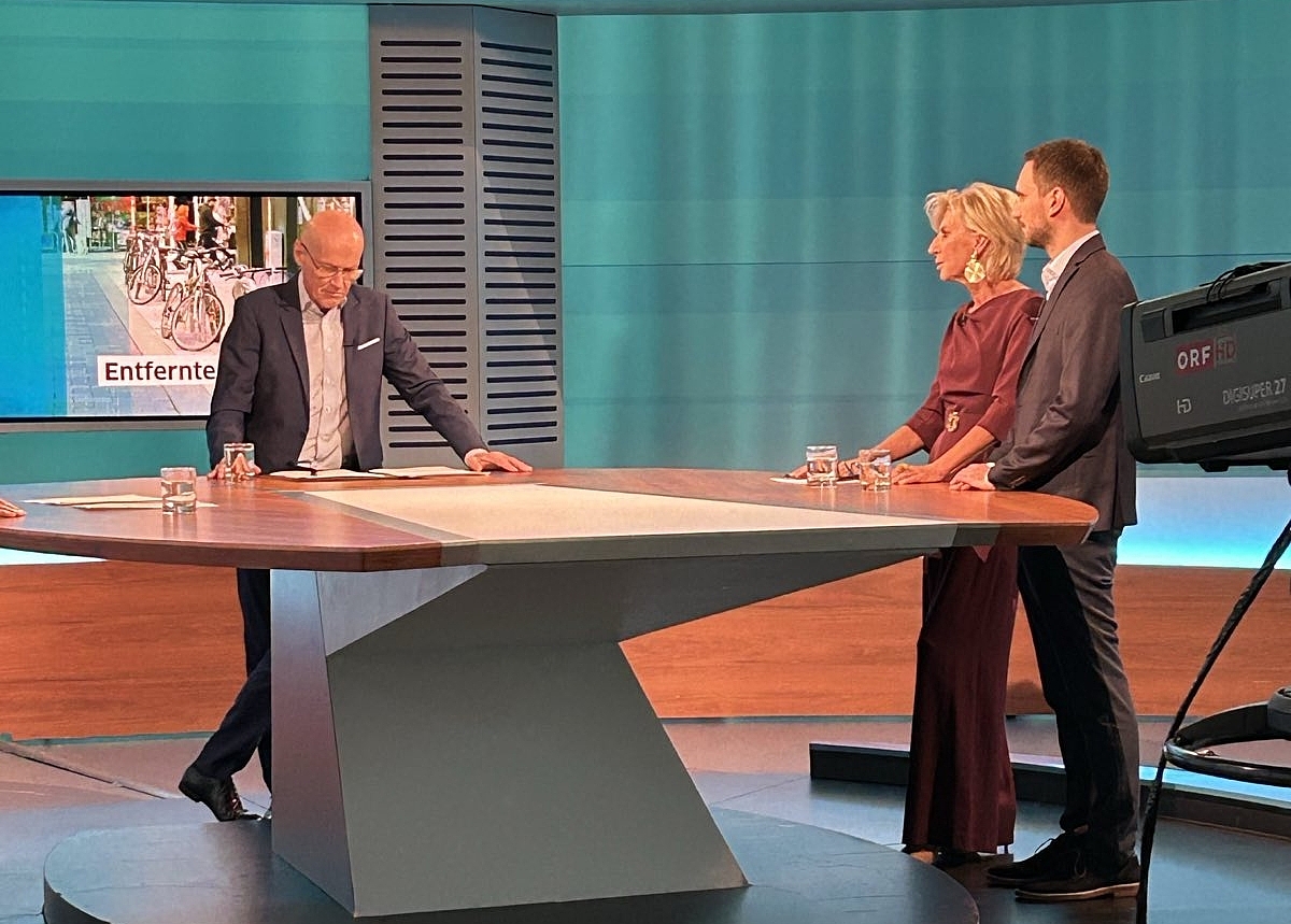 Volksanwältin Gaby Schwarz im ORF Studio bei der Sendung Bürgeranwalt. Sie steht mit dem Moderator Peter Resetarits und einem Beschwerdeführer an einem Tisch.