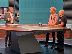 Ombudswoman Gaby Schwarz stands in the ORF studio, next to presenter Peter Resetarits