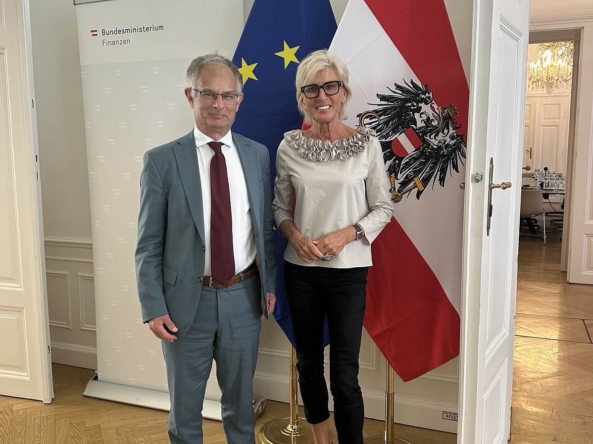 2 Personen stehend, links Finanzminister Markus Marterbauer, rechts Volksanwältin Gaby Schwarz