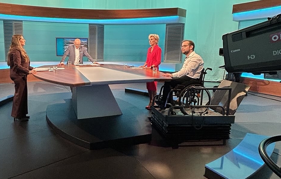 4 Personen stehen im ORF Studio, darunter Volksanwältin Gaby Schwarz und neben ihr der Beschwerdeführer im Rollstuhl.