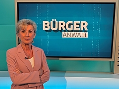 Volksanwältin Gaby Schwarz steht im ORF Studio vor einem Screen mit dem Titel "Bürgeranwalt".
