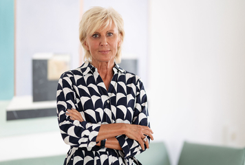 Volksanwältin Gaby Schwarz steht mit verschränkten Armen in ihrem Büro.