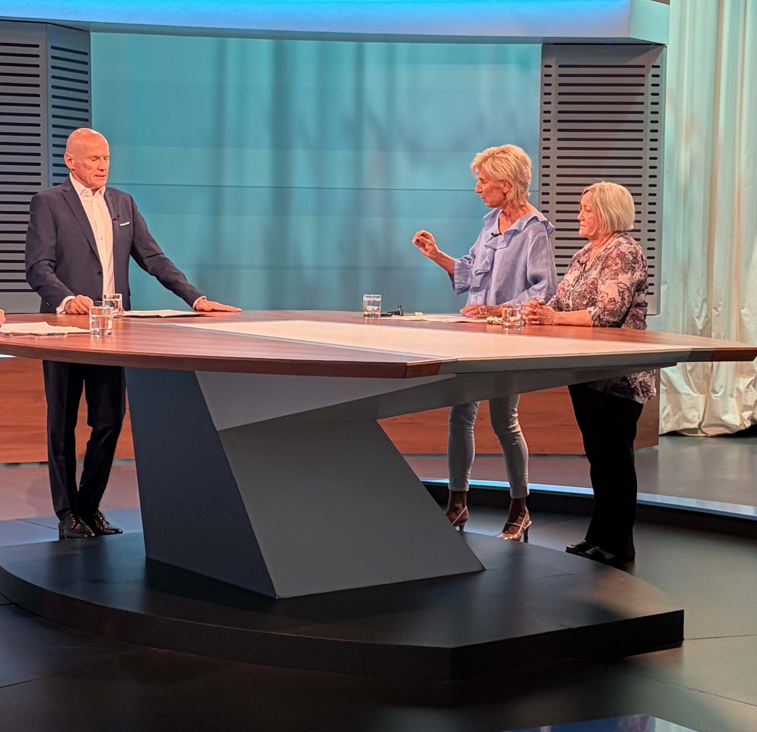 Volksanwältin Gaby Schwarz steht im ORF Studio zwischen dem Moderator und der Beschwerdeführerin.
