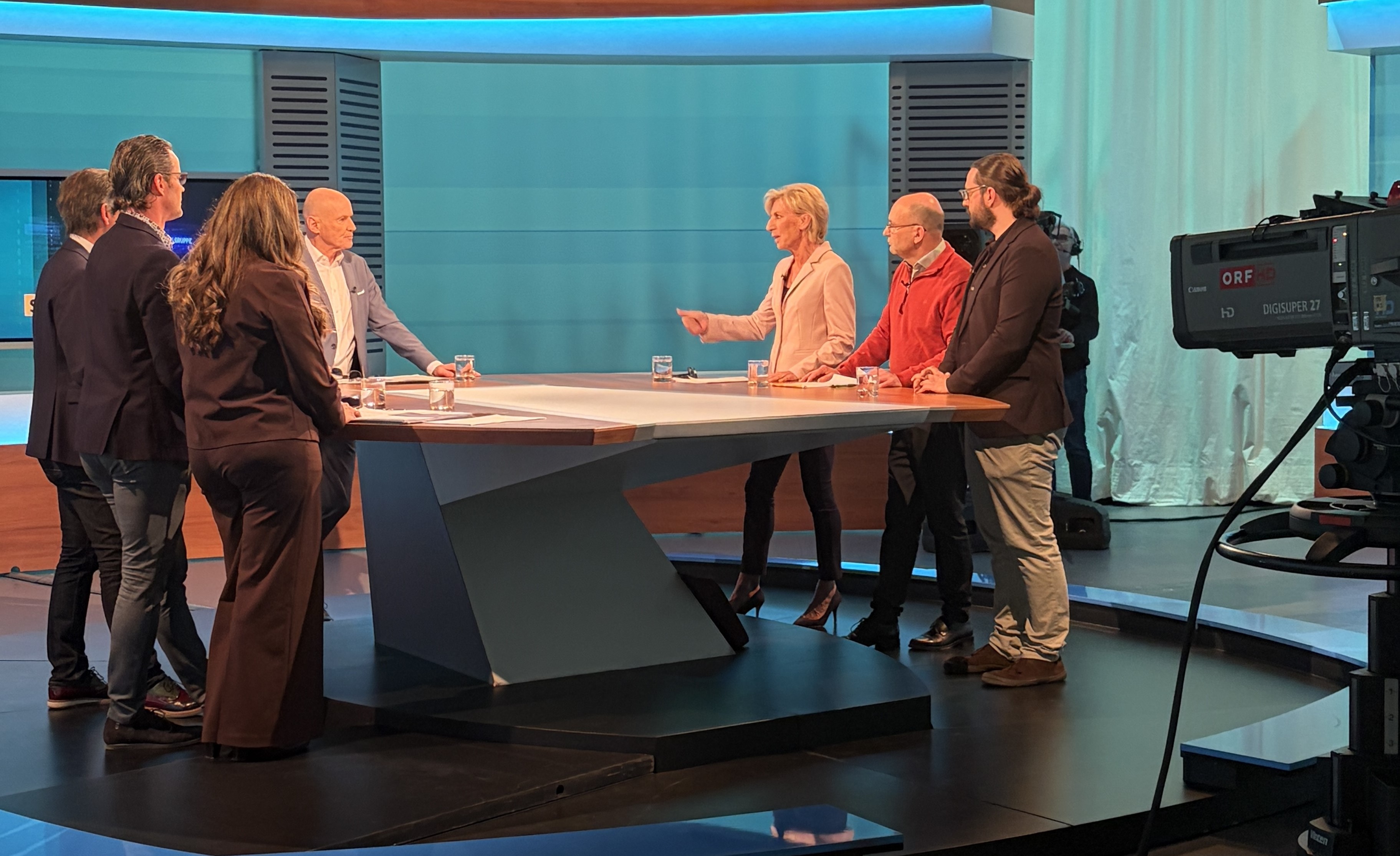 Volksanwältin steht im ORF Studio mit weiteren 6 Personen