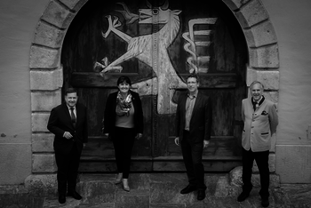 Volksanwalt Amon, Landtagspräsidentin Khom, Volksanwalt Achitz und Volksanwalt Rosenkranz vor Holztor mit Steirischem Wappen 
