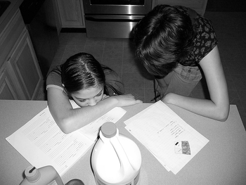Frau lernt mit Mädchen am Küchentisch