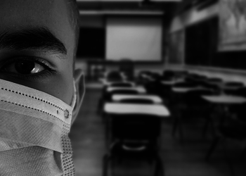 Schulkind mit Maske im Klassenzimmer