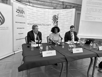 Ombudsman Achitz, Isiba, CEO of the NGO ZARA - Civil Courage & Anti-Racism-Work and Horn from the  Austrian League for Human Rights sitting in front of the press wall of the Austrian Ombudsman Board.