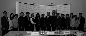 Vertreterinnen und Vertreter der südkoreanischen Delegation mit Günther Kräuter vor der Pressewand der Volksanwaltschaft
