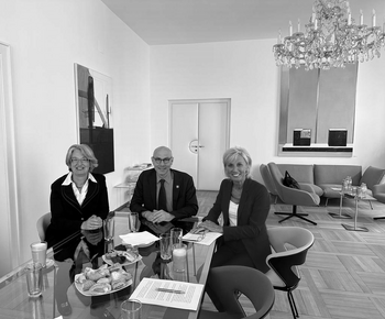 Drei Personen sitzend bei Tisch im Büro von Volksanwältin Schwarz.