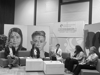 Bernhard Achitz, Renate Frech, Verena Humer, Rihab Toumi und Silvia Dinhof-Cueto sitzend auf grünen Sofas vor Schwarz-Weiß-Sujets von menschengroßen Gesichtern.